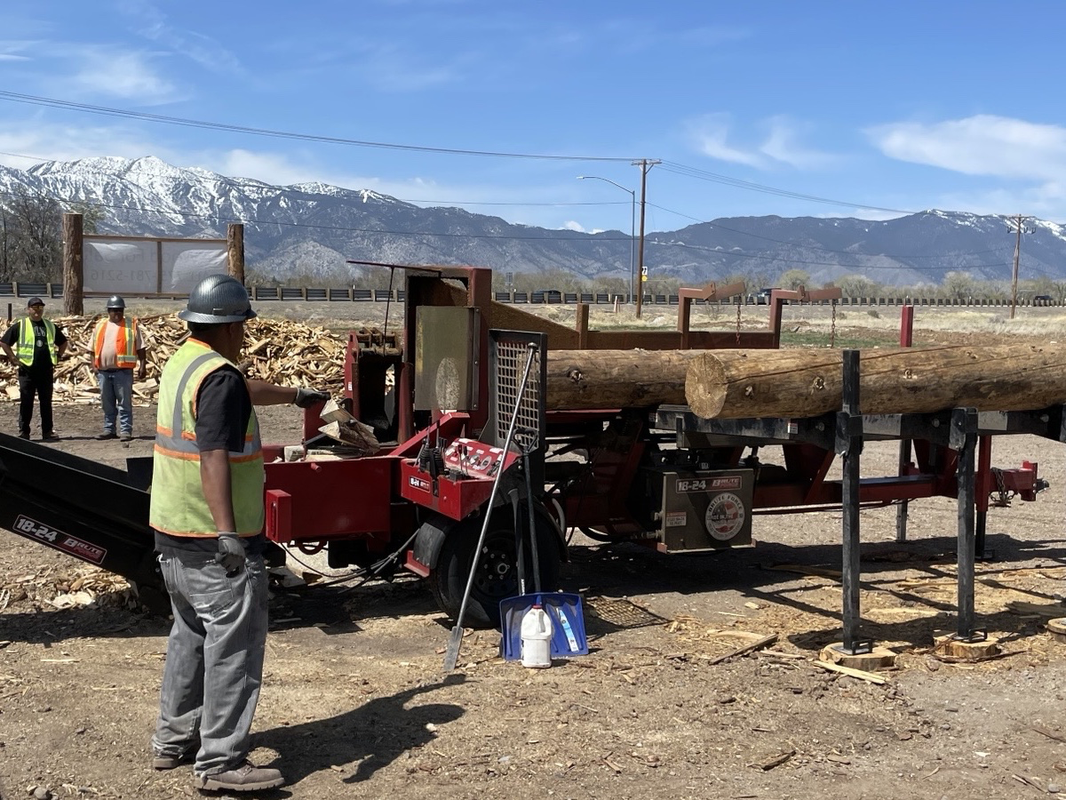 Field crew member operating industrial wood splitter at Washoe Wood Yard. Photo by Scott Burdette, USFS.